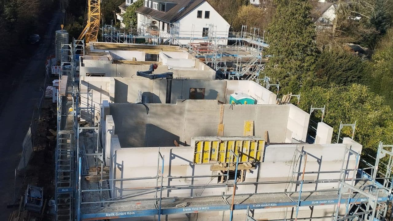 Rohbau eines Wohngebäudes mit Kran und Gerüst